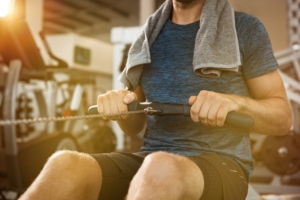 Young man exercising with a rowing machine