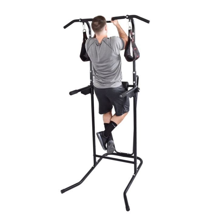 Man pulling himself upward on stamina power tower with bars