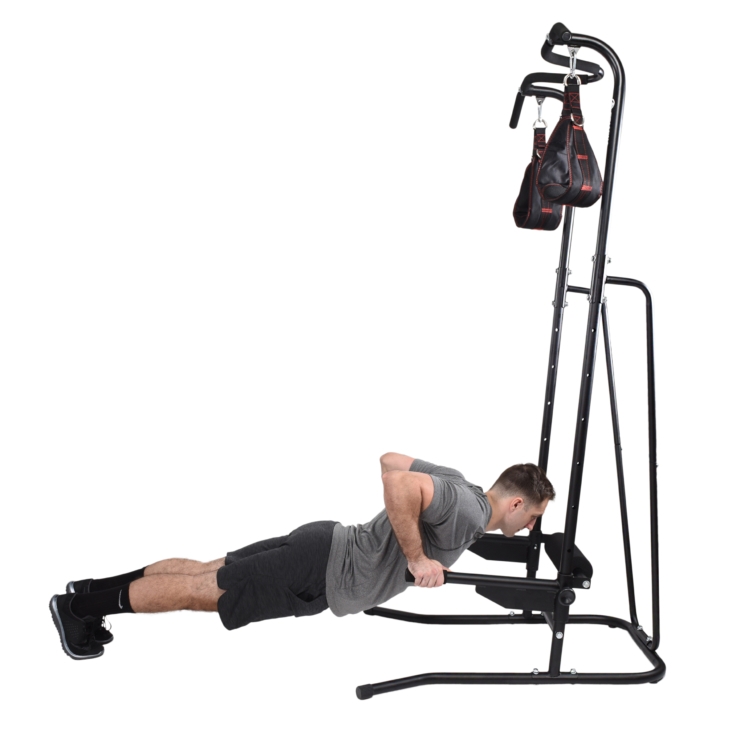 Man pushing himself up (facing the ground) on power tower while the bars are on the lowest setting.