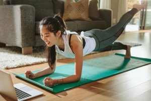 Woman watching sports training online on laptop